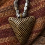 Cuentas grises con colgante triangular de bronce calado · en su ambiente