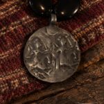 Cuentas negras con medalla de plata (detalle) · en su ambiente